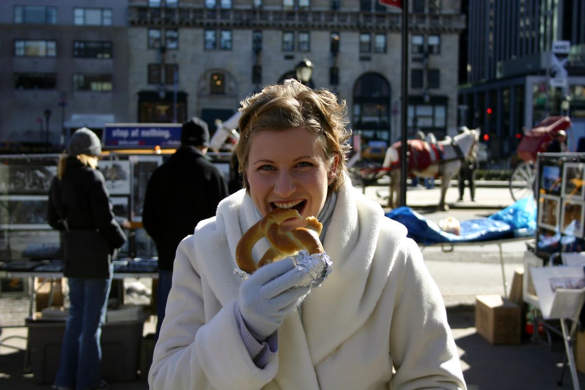 Enoying New York street food from a mobile vendor, cheese filled hot prezels.