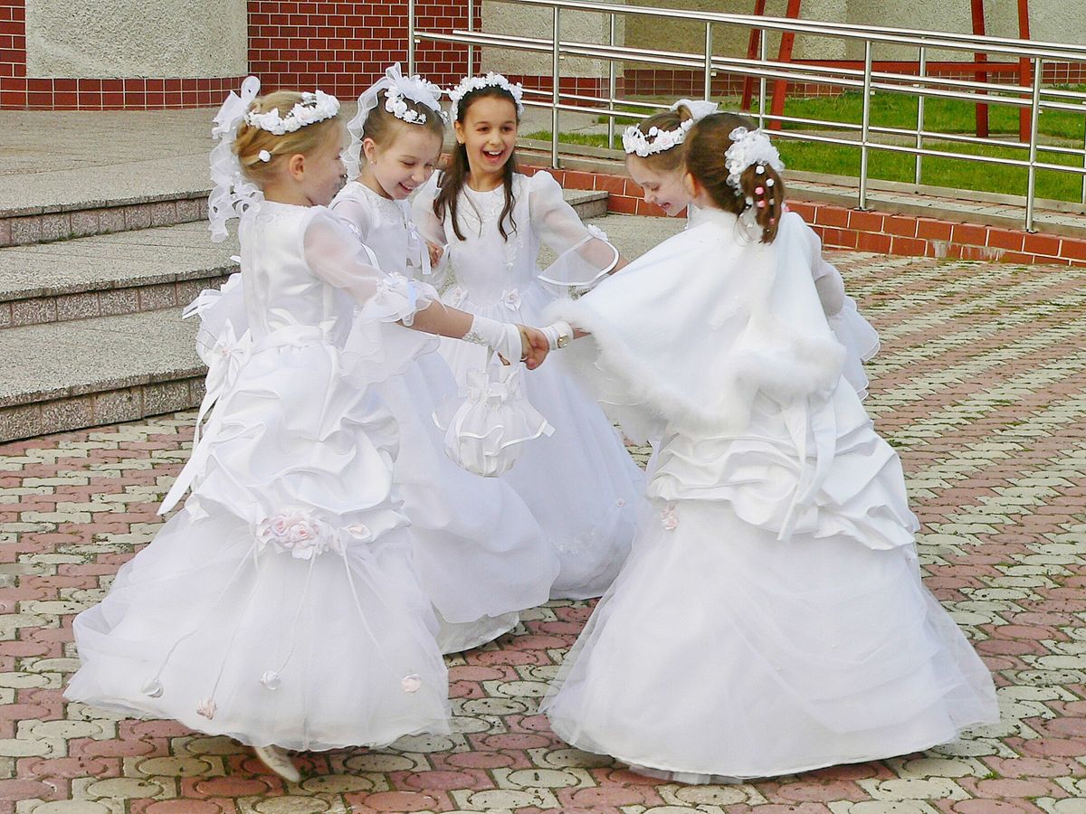 Kommunionmädchen tanzen spontan vor der Kirche